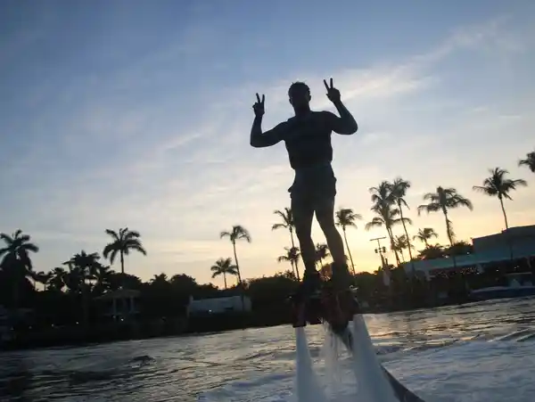 Flyboard rider above the water at sunset