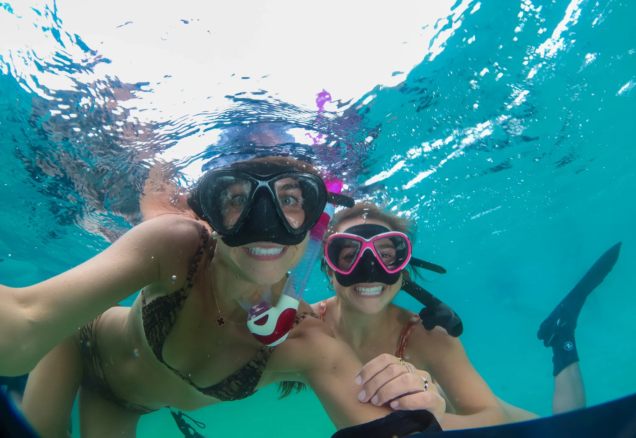 Two guests snorkeling in clear blue water